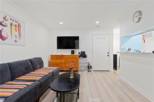 living area with ornamental molding, light wood-style floors, recessed lighting, and baseboards