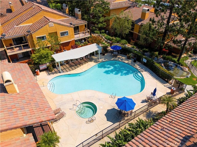 community pool featuring fence, a patio, and a gazebo