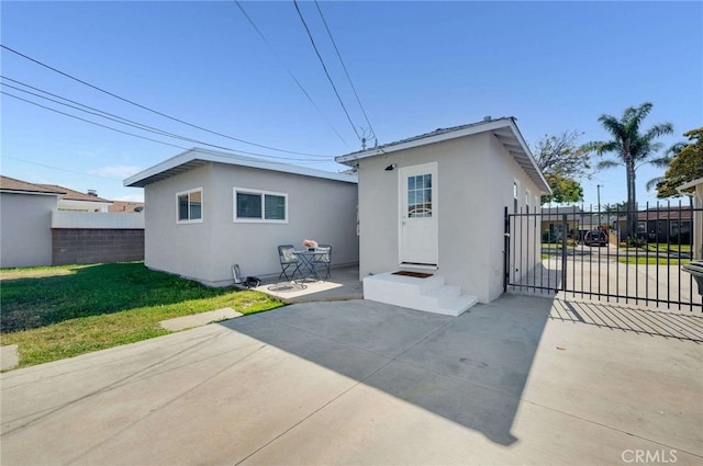 5642 Briercrest Ave, Lakewood, CA 90713 - rear view of house featuring stucco siding, a patio, a gate, and driveway
