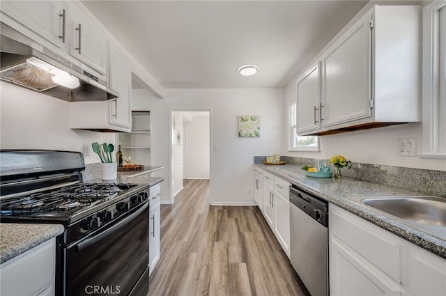 5642 Briercrest Ave, Lakewood, CA 90713 - kitchen featuring black gas stove, stainless steel dishwasher, under cabinet range hood, light wood-style floors, and white cabinets