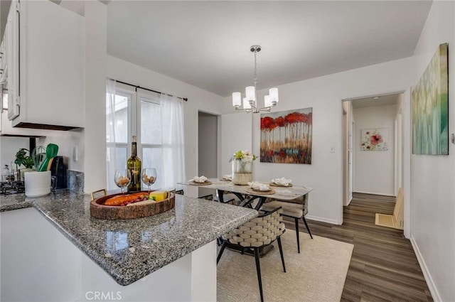 5642 Briercrest Ave, Lakewood, CA 90713 - kitchen with dark wood-style floors, a chandelier, baseboards, stone countertops, and pendant lighting