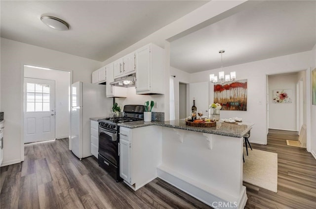 5642 Briercrest Ave, Lakewood, CA 90713 - kitchen featuring gas range, under cabinet range hood, a peninsula, dark wood-style flooring, and dark stone countertops