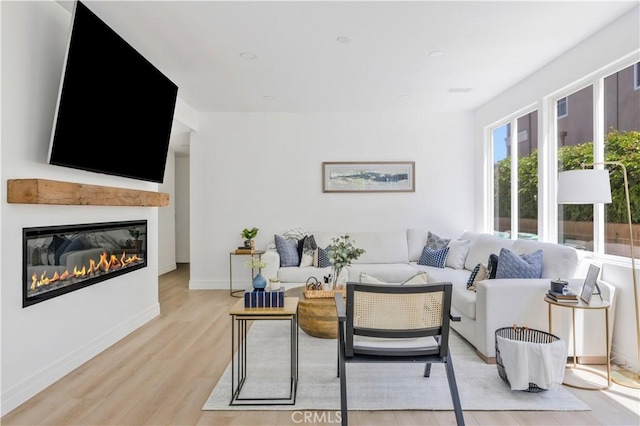 17 Candlewood, Irvine, CA 92620 - living area with light wood-type flooring, a glass covered fireplace, and baseboards