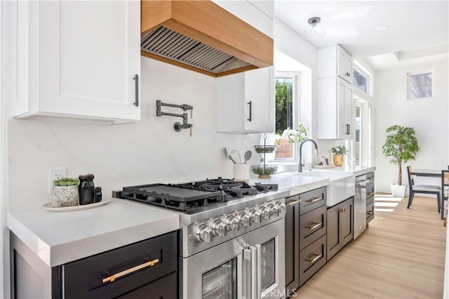 17 Candlewood, Irvine, CA 92620 - kitchen featuring stainless steel stove, a sink, white cabinetry, and light countertops