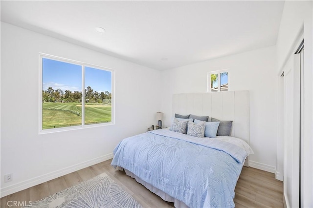 17 Candlewood, Irvine, CA 92620 - bedroom featuring light wood-style floors, baseboards, and golf course view