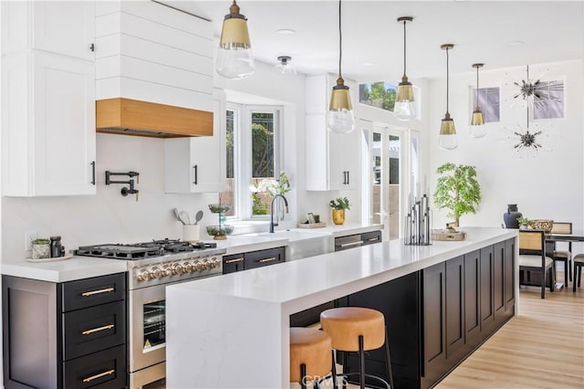17 Candlewood, Irvine, CA 92620 - kitchen featuring high end stainless steel range, white cabinets, light countertops, and a sink