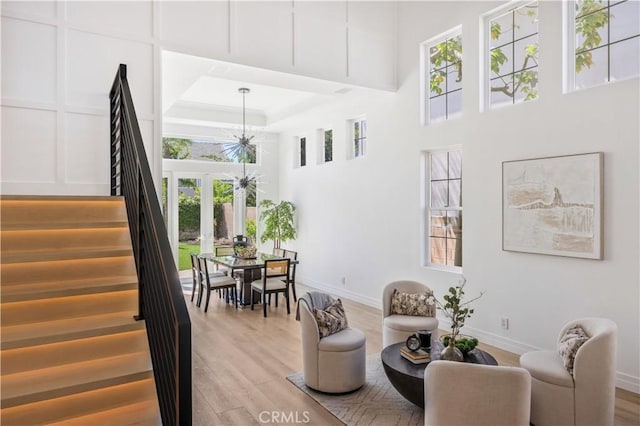 17 Candlewood, Irvine, CA 92620 - sitting room with stairway, light wood-type flooring, a towering ceiling, baseboards, and healthy amount of natural light