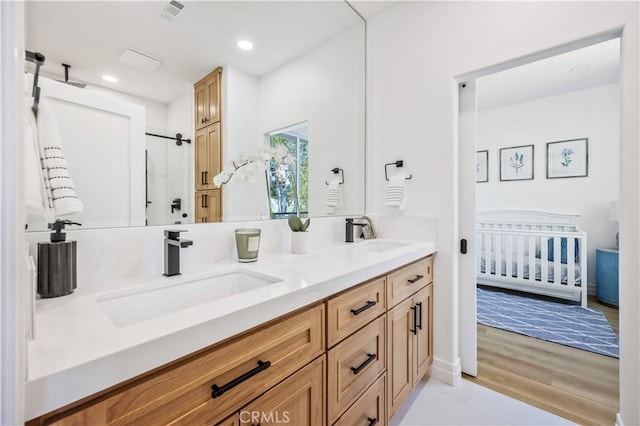 17 Candlewood, Irvine, CA 92620 - bathroom featuring double vanity, a shower, wood finished floors, and recessed lighting
