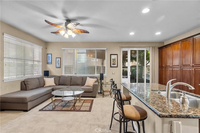 living room with a ceiling fan, recessed lighting, and light carpet