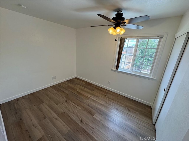empty room featuring wood finished floors, ceiling fan, and baseboards