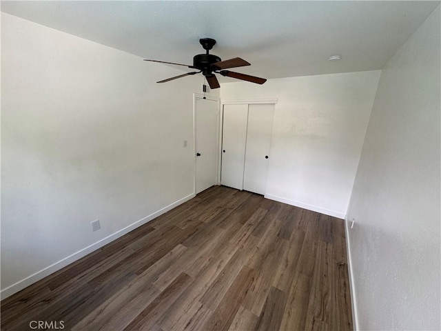 unfurnished room featuring ceiling fan, dark wood-style floors, and baseboards