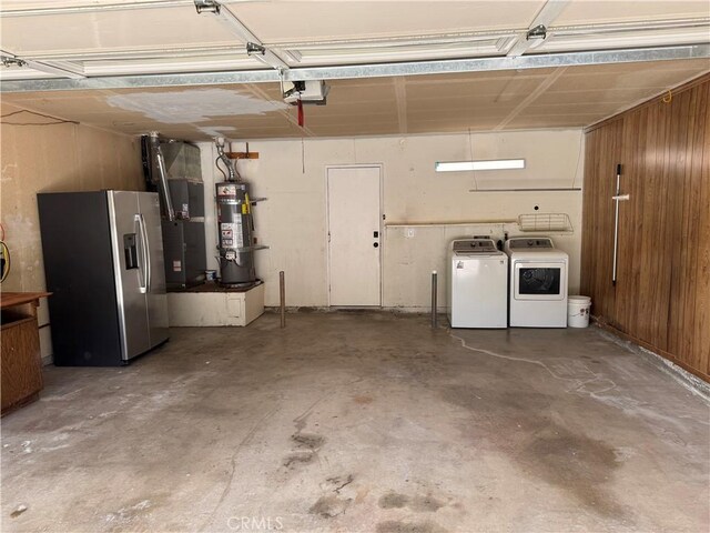 garage with stainless steel refrigerator with ice dispenser, water heater, washing machine and dryer, a garage door opener, and heating unit