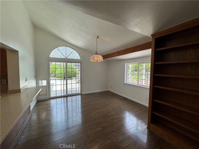 unfurnished dining area featuring dark wood-type flooring, a chandelier, baseboards, lofted ceiling, and a textured ceiling