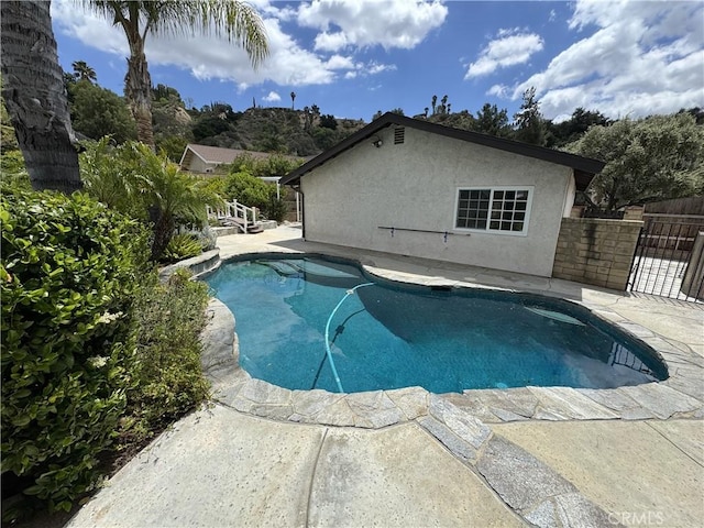 view of swimming pool featuring a patio area and fence
