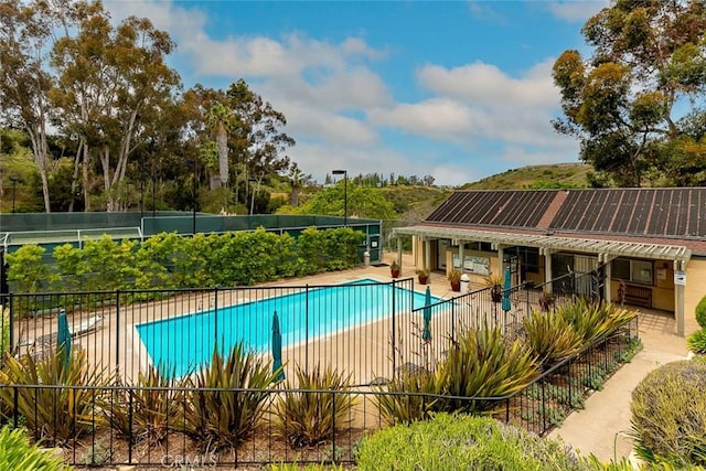 community pool with fence and a patio area