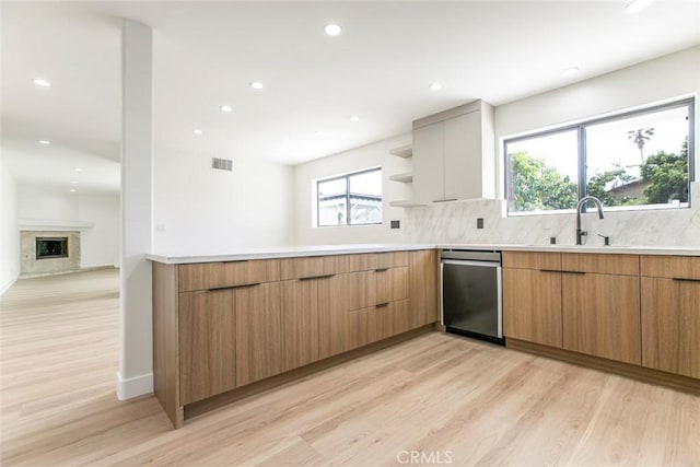 kitchen featuring stainless steel dishwasher, light wood-style floors, open shelves, modern cabinets, and recessed lighting