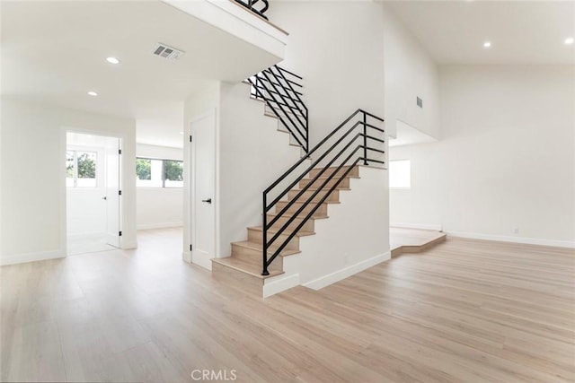 stairway featuring wood finished floors, recessed lighting, and baseboards