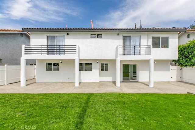 rear view of property with a balcony, a patio area, and stucco siding