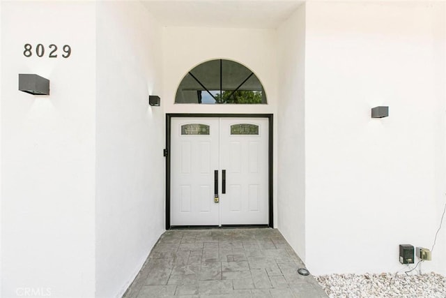 view of exterior entry featuring stucco siding
