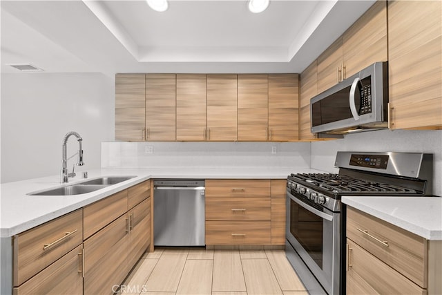 206 Eisenhower, Placentia, CA 92870 - kitchen with stainless steel appliances, a sink, a tray ceiling, a peninsula, and light stone countertops