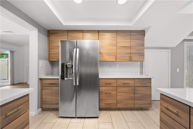 206 Eisenhower, Placentia, CA 92870 - kitchen with stainless steel refrigerator with ice dispenser, a raised ceiling, light countertops, and brown cabinetry