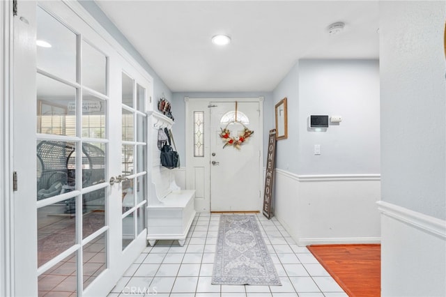entrance foyer featuring healthy amount of natural light, light tile patterned floors, and french doors