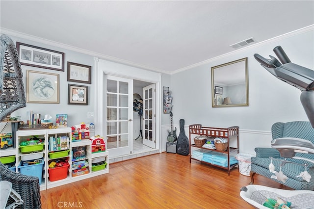 recreation room featuring crown molding and wood finished floors