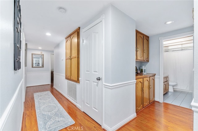 hall with light wood-style floors and recessed lighting