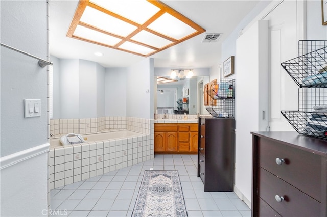 bathroom with a garden tub, vanity, and tile patterned flooring