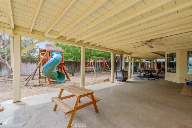 view of patio / terrace featuring a playground, a fenced backyard, and ceiling fan