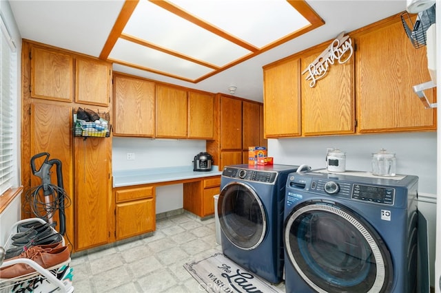 laundry area with cabinet space, light floors, washer and clothes dryer, and a desk