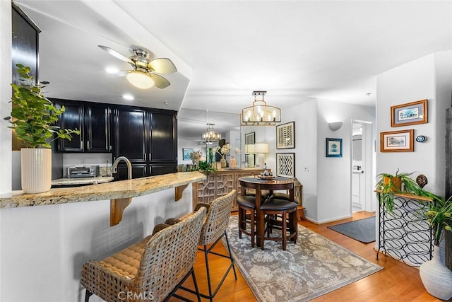 11165 Affinity Ct Unit 32, San Diego, CA 92131 - dining room featuring ceiling fan, light wood-type flooring, a chandelier, and baseboards