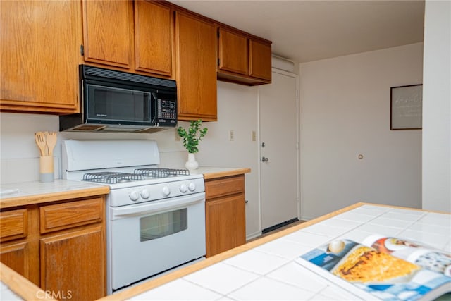 8541 San Clemente Dr, Rancho Cucamonga, CA 91730 - kitchen with white gas stove, black microwave, and brown cabinets