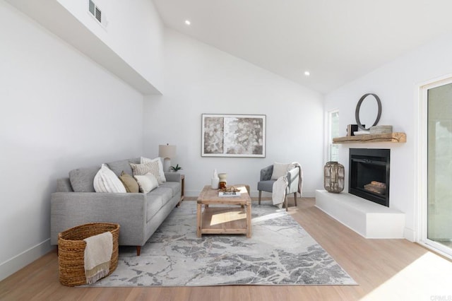 1142 Cabot Ct, Vista, CA 92081 - living room with a fireplace with raised hearth, wood finished floors, recessed lighting, high vaulted ceiling, and baseboards