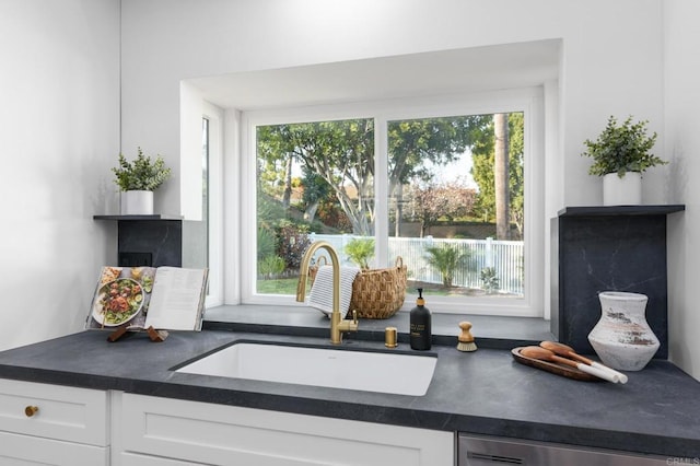 1142 Cabot Ct, Vista, CA 92081 - kitchen view of a sink, dark countertops, white cabinetry, and a fireplace