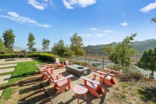 4233 Powell Way Unit 102, Corona, CA 92883 - view of patio with an outdoor fire pit, fence, and a mountain view