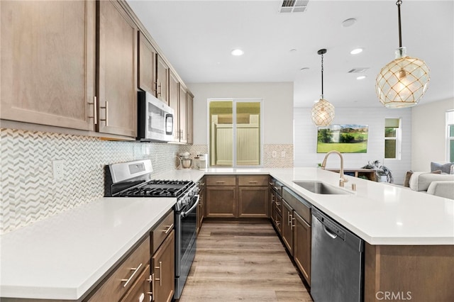 4233 Powell Way Unit 102, Corona, CA 92883 - kitchen with appliances with stainless steel finishes, a sink, a peninsula, plenty of natural light, and recessed lighting