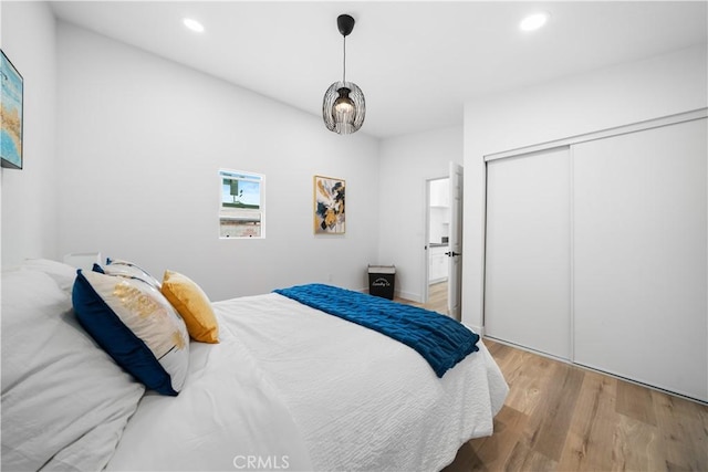 bedroom featuring wood finished floors, recessed lighting, and a closet