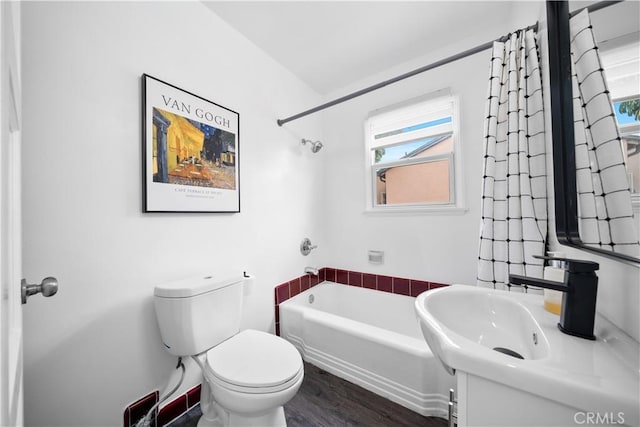 bathroom featuring healthy amount of natural light, a tub to relax in, toilet, and wood finished floors