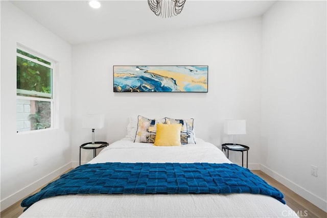 bedroom featuring baseboards, wood finished floors, and recessed lighting