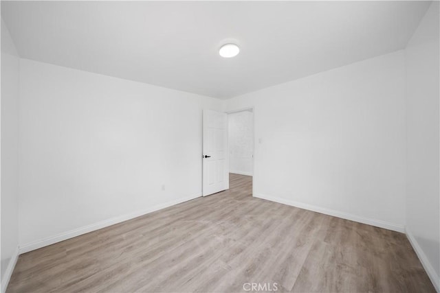 spare room with wood finished floors and baseboards