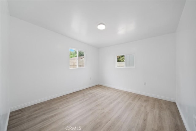 unfurnished room featuring light wood finished floors and baseboards