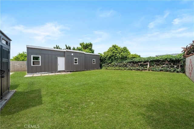 view of green lawn featuring an outbuilding