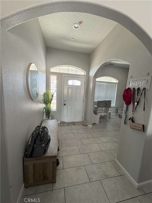 17602 Main St, Hesperia, CA 92345 - entryway featuring arched walkways, a textured ceiling, baseboards, and light tile patterned floors