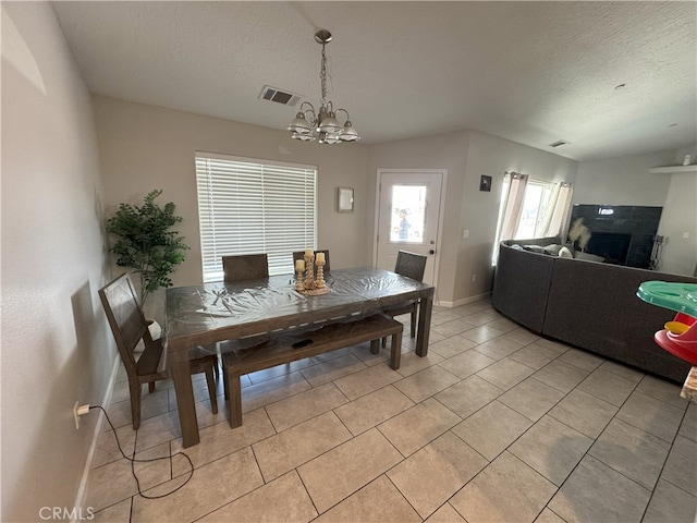 17602 Main St, Hesperia, CA 92345 - dining space with a chandelier, light tile patterned flooring, a textured ceiling, baseboards, and a tiled fireplace