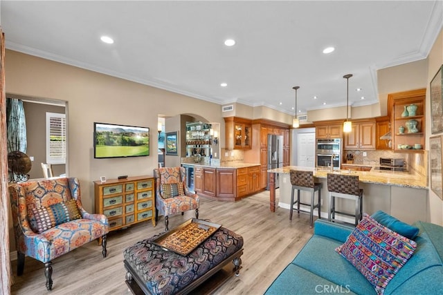 37 Giotto, Aliso Viejo, CA 92656 - living room featuring arched walkways, light wood-style floors, recessed lighting, ornamental molding, and decorative columns