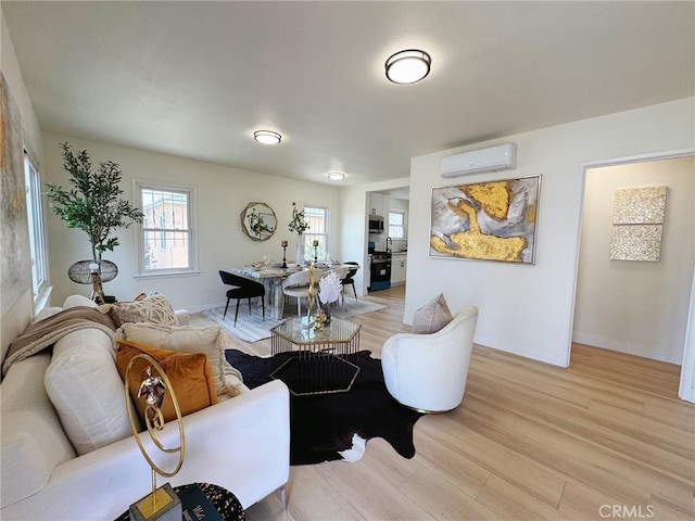 living area featuring a wall mounted AC, light wood-type flooring, and baseboards