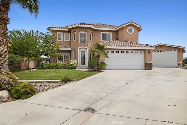 13985 Evergreen Ln, Victorville, CA 92395 - mediterranean / spanish-style house featuring a garage, a tiled roof, concrete driveway, and stucco siding