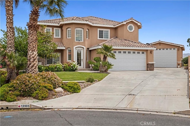 13985 Evergreen Ln, Victorville, CA 92395 - mediterranean / spanish house featuring a tiled roof, an attached garage, stucco siding, concrete driveway, and a front lawn