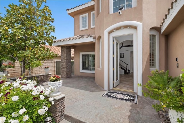 13985 Evergreen Ln, Victorville, CA 92395 - doorway to property featuring stucco siding, a tile roof, and a patio area